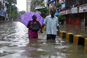 Old Couple walking in flooded Mumbai Road