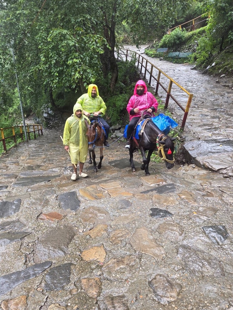 Two of the group on ponies, pony-wallah walking alongside in the rain